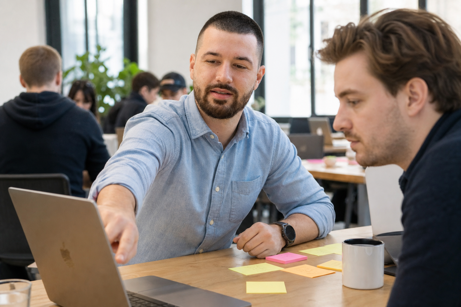 Chandler Drake Talley photo: collaborating at a shared office table Chandler Drake Talley, Senior AI Engineer — collaborating at a shared office table