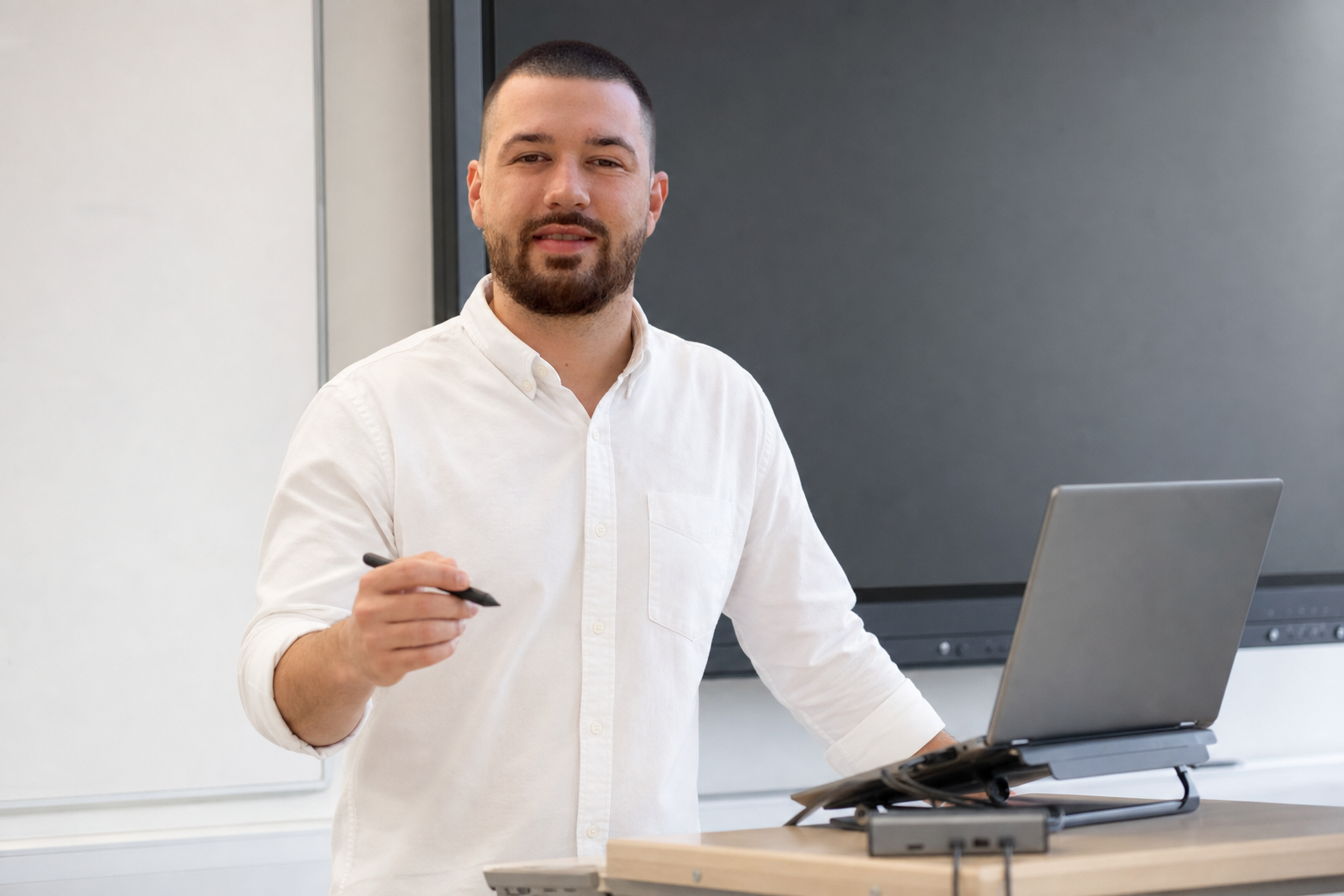 Chandler Drake Talley photo: teaching with a laptop near a smartboard Chandler Drake Talley, Senior AI Engineer — teaching with a laptop near a smartboard